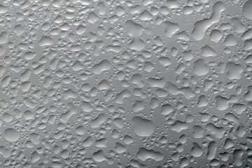 Water drops on grey glass surface, top view