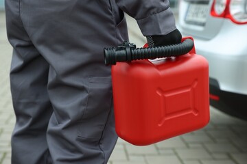 Man with canister near car outdoors, closeup