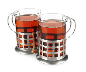 Glasses of aromatic tea in holders isolated on white
