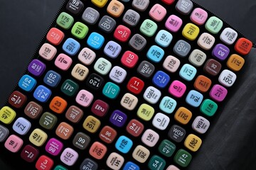 Different double sided markers on black background, top view