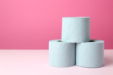 Blue toilet paper rolls on pink background. Space for text