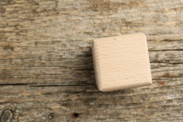 One cube on wooden table, top view. Space for text