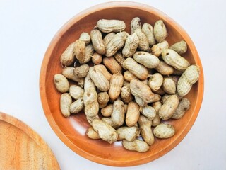 Boiled peanuts (Arachis Hypogaea L.) in a wooden bowl on a white background. 