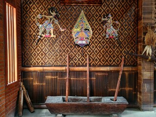 wayang kulit is displayed on a wooden wall indonesian and javanese traditional shadow puppets made...