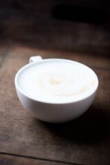 Cappuccino on dark wooden background. Soft focus. Close up. 