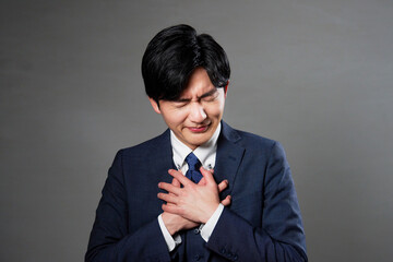 胸が痛むビジネスマン　黒背景