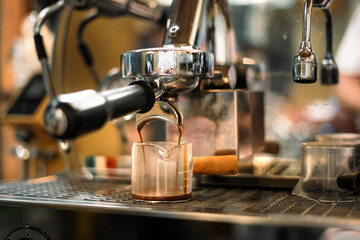 Espresso machine pouring hot coffee in a cafe
