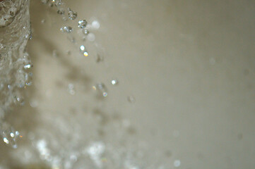 Water flowing from the tap in the kitchen. Shallow depth of field.