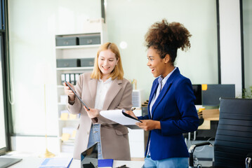 Obraz premium Businesswoman leading team meeting and using tablet and laptop computer with financial