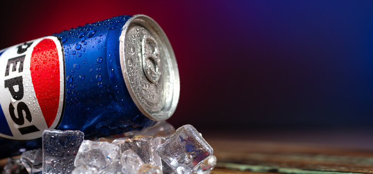 Close-up of a can of coca cola. Pepsi advertisement. Iron can of cola on a table with ice cubes