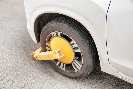 Yellow wheel clamp on an illegally parked car