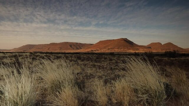 Highland hill plateau landscape: Dry grasses blow in foreground breeze