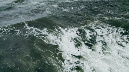 Top view of the foaming sea waves at high tide. Drone video, only sea waves in the frame