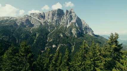 Drone view of a high-altitude valley with rocky peaks and slopes overgrown with spruce forest