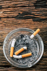 cigarette in ashtray on wooden background