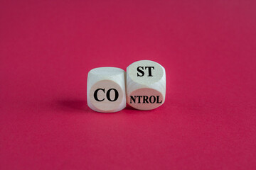 Cost control symbol. Turned a wooden cube and changes the concept word Cost to Control. Beautiful red background. Business cost control concept