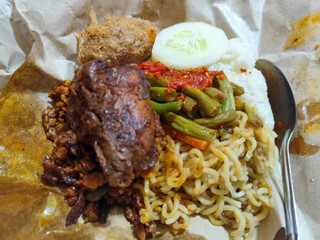 Nasi campur (Nasi Rames) is a typical Javanese Indonesian dish, which consists of white rice served with various side dishes.