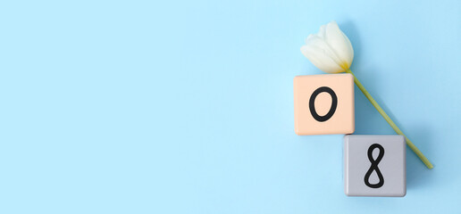 Cube calendar with date 08 and beautiful white tulip on blue background. International Women's Day