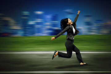 Obraz premium Businesswoman Running Towards Success in a Fast-Paced City Environment