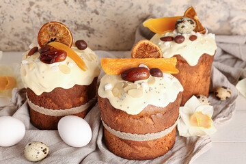 Easter cake with narcissus and eggs on white wooden table near beige grunge wall