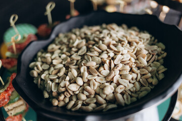 Close-Up View of Salted Peanuts in a Black Tray at a Buffet