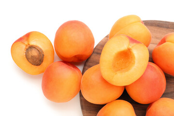 Wooden board with ripe apricots isolated on white background