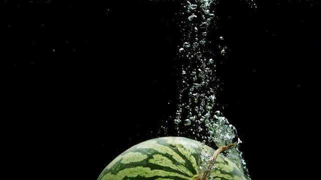 water melon submerging in water with bubbles