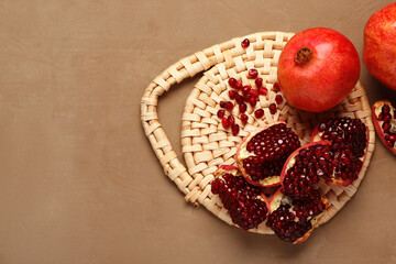 Fresh pomegranates and seeds on brown background