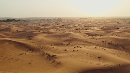 Cars driving off-road among sand dunes in the desert. Drone view