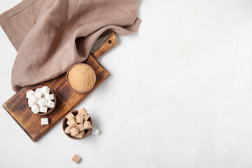 Bowls with different types of sugar on white background