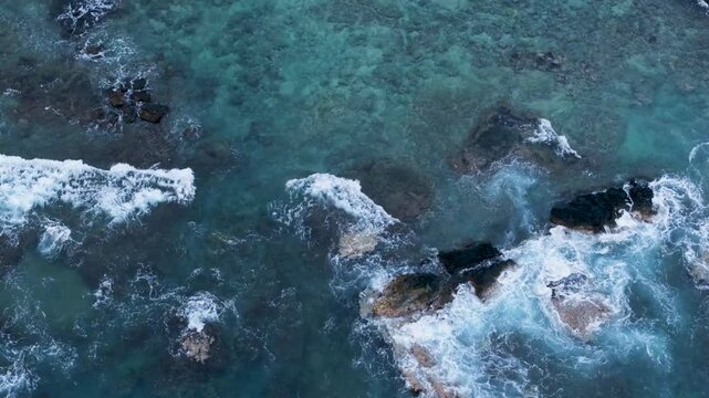 Overhead view waves break on black lava rocks Hawaii