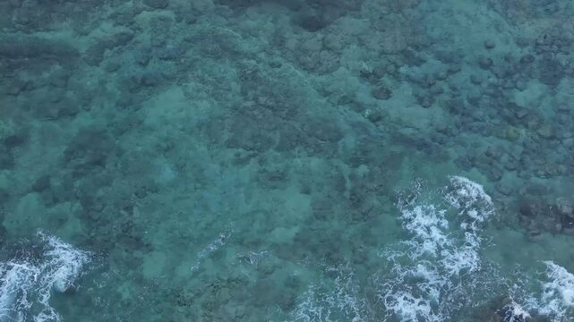 Overhead view waves break gently over tide pool rocks