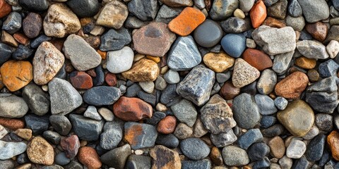 Colorful multi-sized gravel stones in various hues of orange, brown, gray, and blue are scattered closely, creating a textured natural background.
