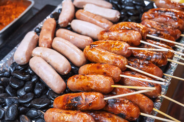 sausages on sticks grilled on the rocks. Street fast food in Asia in Vietnam
