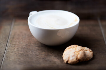 Cappuccino on dark wooden background. Soft focus. Close up.