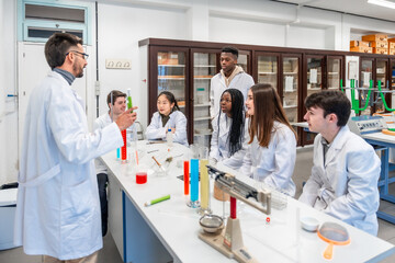 Chemistry teacher explaining experiment to students in university laboratory