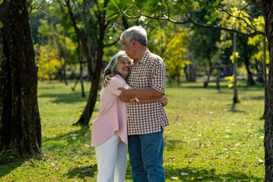 Romantic elderly couple holding hands looks happy in the park