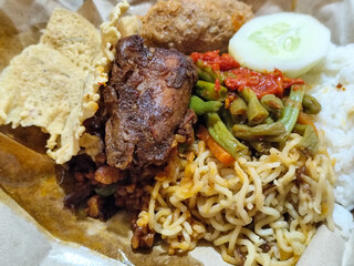 Nasi campur (Nasi Rames) is a typical Javanese Indonesian dish, which consists of white rice served with various side dishes.