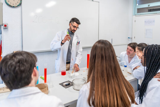 Chemistry teacher making experiment with students in university laboratory