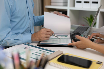 A man and a woman are looking at a piece of paper with graphs on it. They are discussing the data and making decisions based on it
