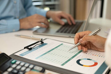 A man and a woman are looking at a piece of paper with graphs on it. They are discussing the data and making decisions based on it
