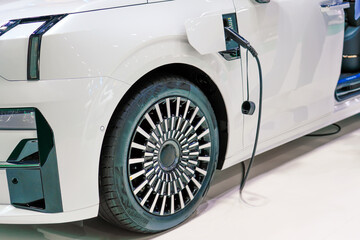 Electric charging machine connected with socket charge nearby front wheel modern car for rechargeable battery.