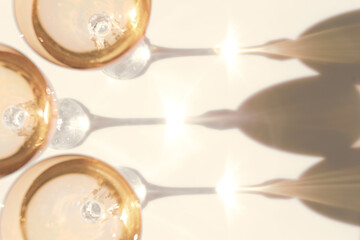 Fancy retro yellow drinking glasses casting hard shadows on background. Retro vintage style. Toned image with yellow color. Image contains blur. Selective focus