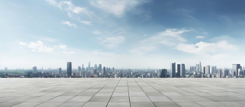 Panoramic city skyline with a blue sky backdrop featuring a wide concrete square floor in the foreground providing ample copy space for text