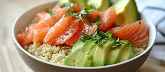 Nutritious quinoa bowl featuring smoked salmon, creamy avocado, and fresh herbs arranged in a white bowl with green and orange accents.