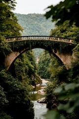 Stone bridge over river in forest setting with mountains, serene scenic vista