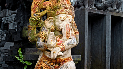 Fototapeta premium An old stone statue of Ganesha covered with moss.