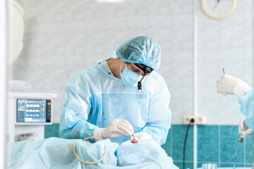 Male otolaryngologist performs septoplasty rhinoplasty in the operating room. Deviated nasal...