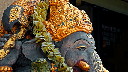 An old stone statue of Ganesha covered with moss.