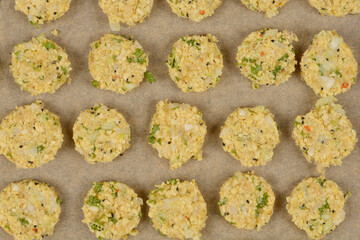 A top-down shot of raw soy patties arranged on parchment paper, ready for baking, showcasing their textured surface and visible ingredients